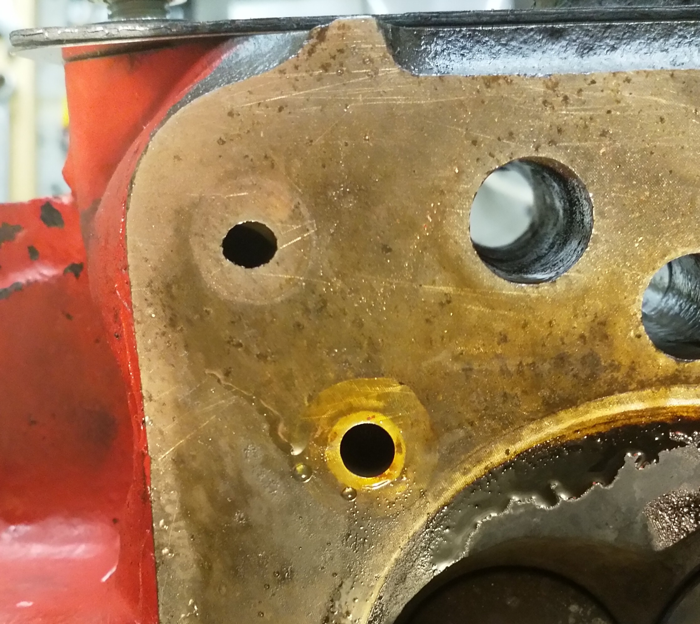 Underside of the head. The leak builds up at the top edge of the head, to the right of the protrusion in the head face, next to the hole for the pushrod.